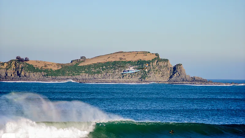 La ola de Mundaka rompiendo con la isla de Izaro al fondo. La foto lleva la marca de Martin Ugalde Photo.
